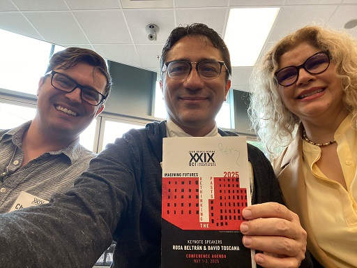 3 people showing conference booklet