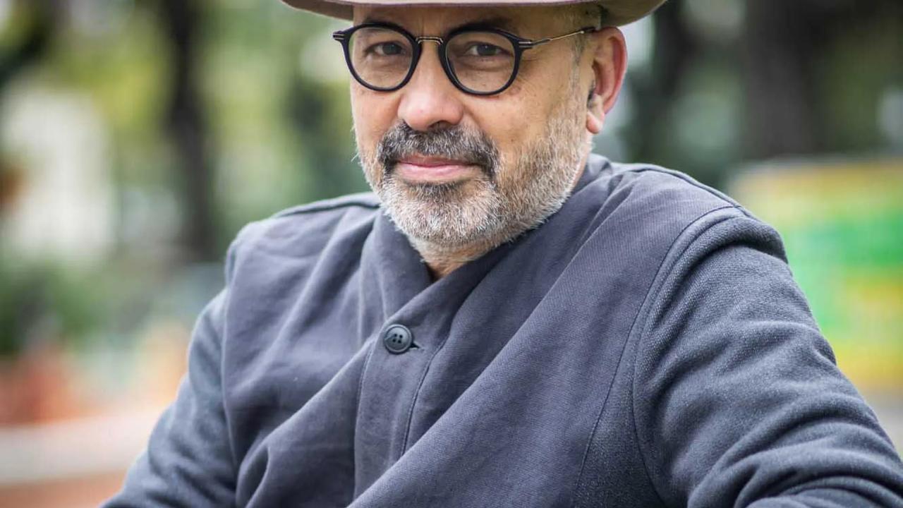 a photo Andrés di Tella wearing glasses and a hat