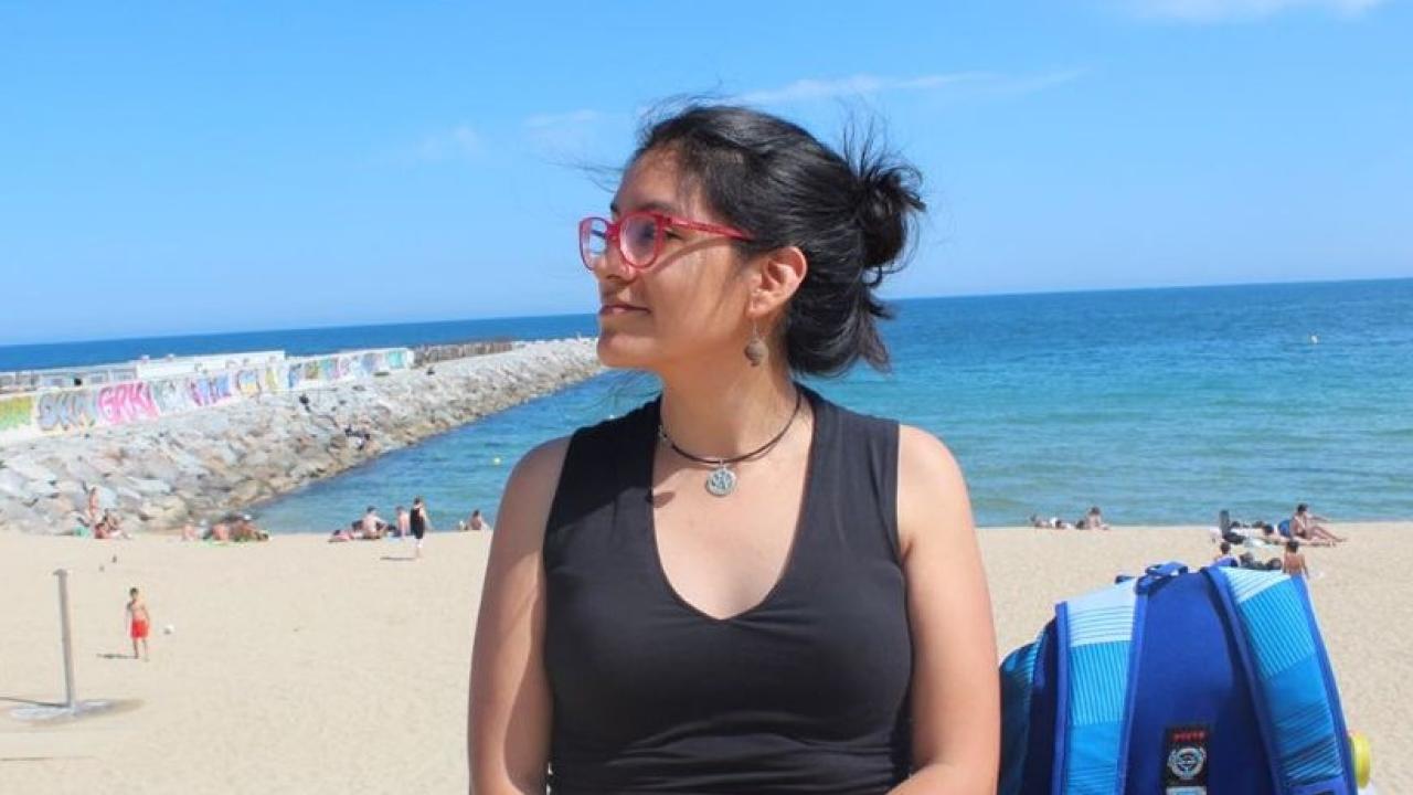 woman sitting on sand of ocean shore