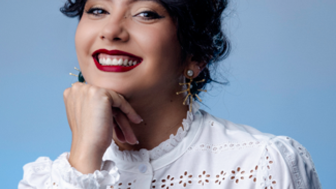 A photo of a woman posing with her hand on her chin.