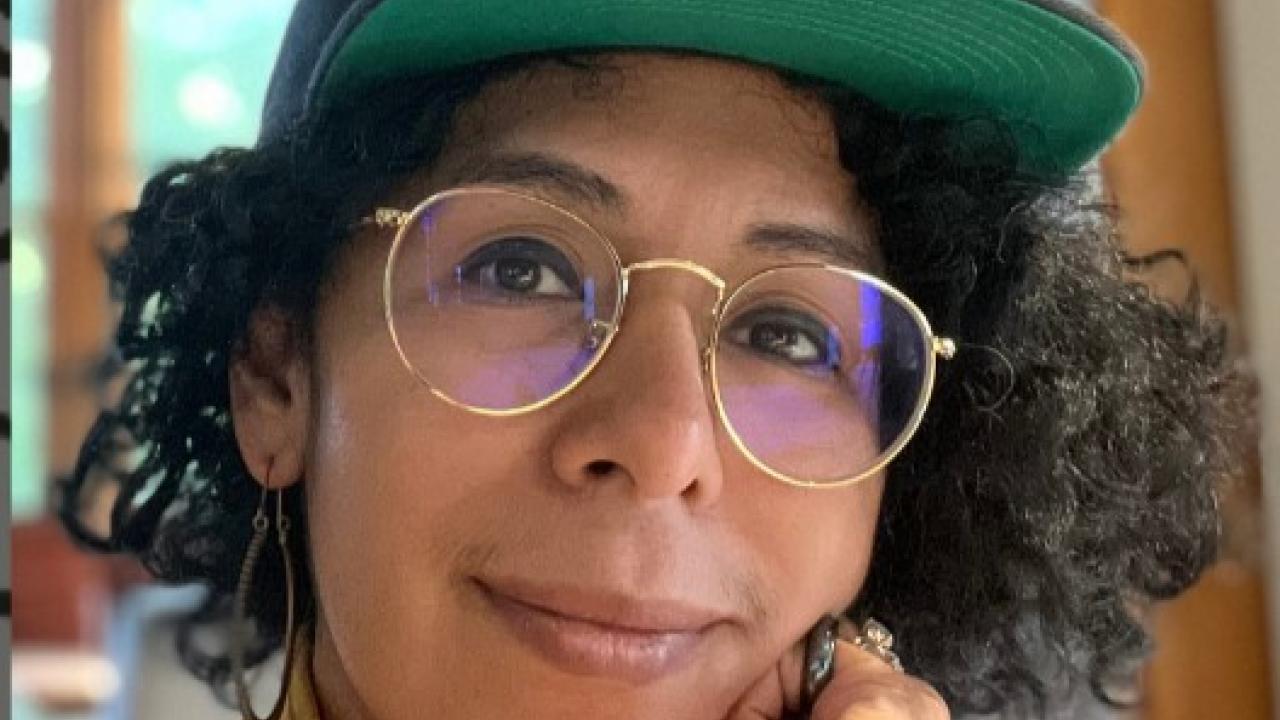 A picture of an artist wearing a baseball cap and glasses.