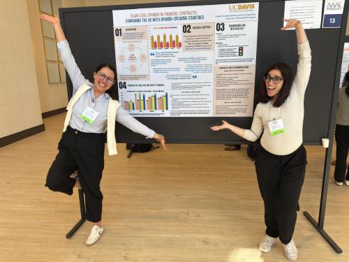 2 graduate students stand near their poster
